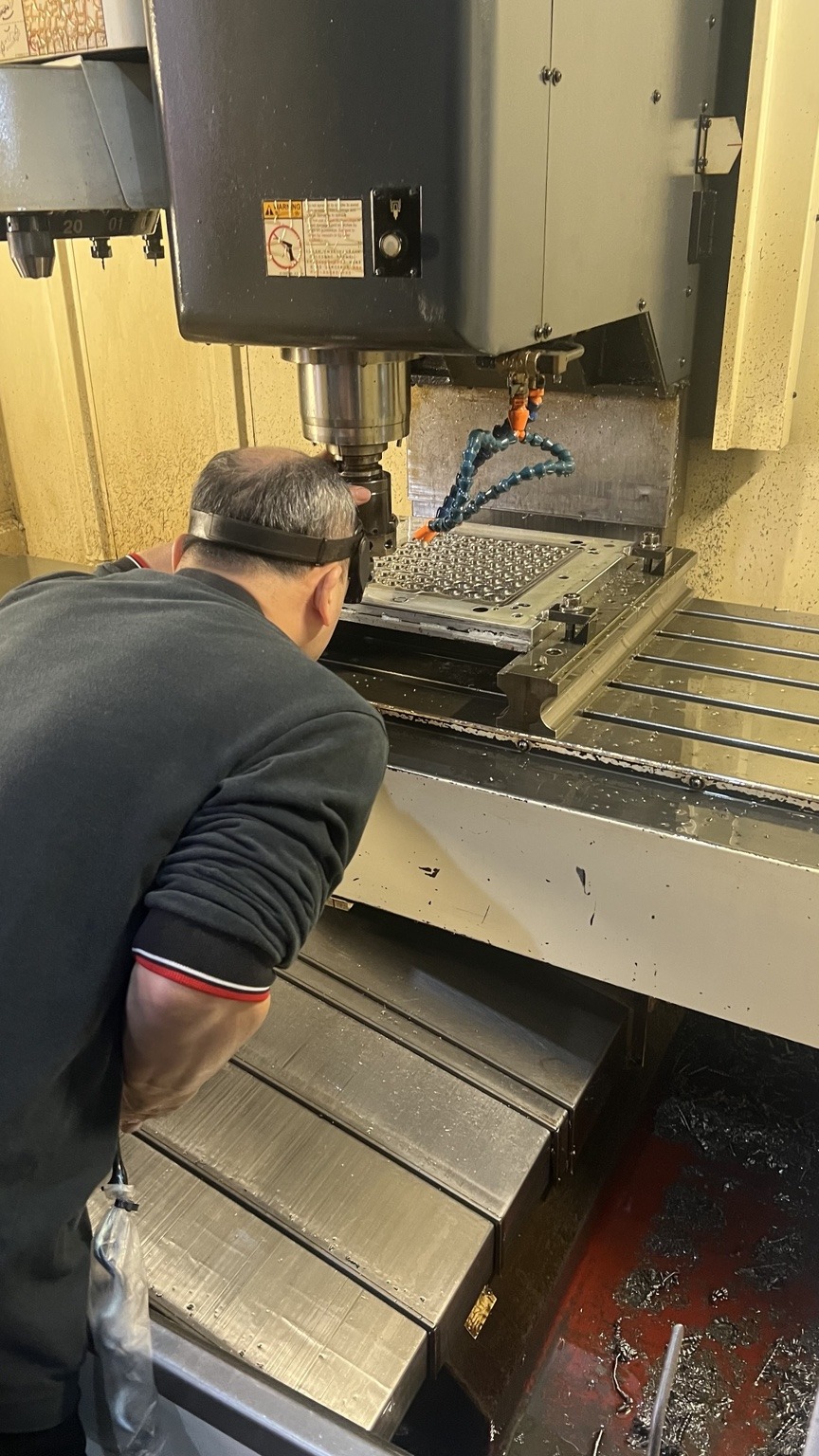 人員於 CNC 機台前進行作業