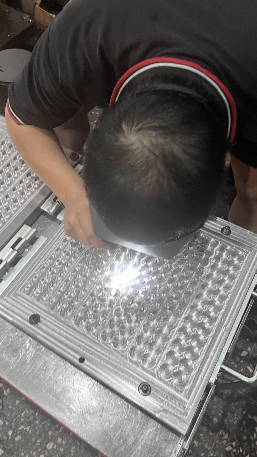人員進行多穴模具細部作業